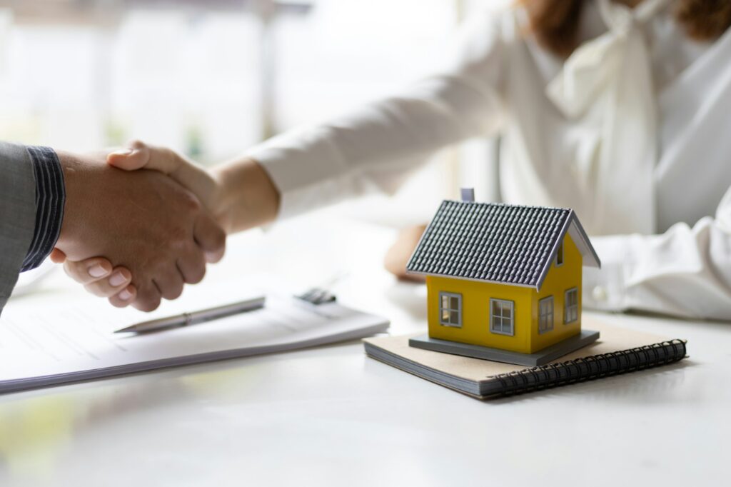 Handshake after reaching a real estate deal. Signing a house rental, mortgage, lease agreement.